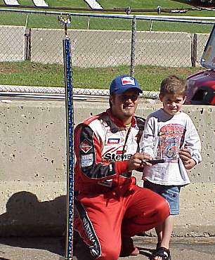 J.J. Yeley poses with the "Pole" trophy after setting fast time for 