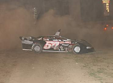 Dane Dacus sets in a cloud of dust in the infield after doing doughnuts celebrating his first late model victory (Photo by Phil Bowden)